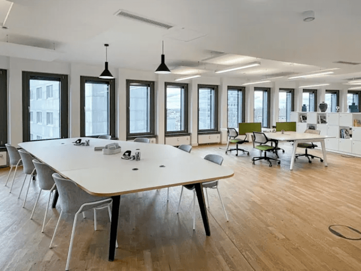 Großes Arbeitsbüro mit vielen Tischen und Stühlen