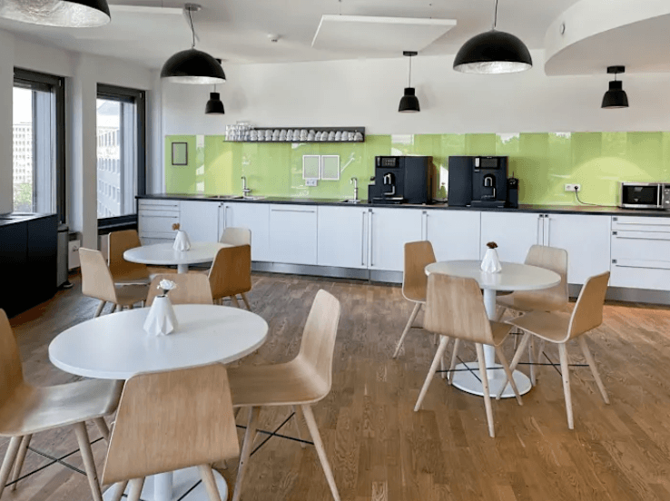 Helle Kantine mit Sitzbereich, Kaffeeküche, Esstischen und Stühlen